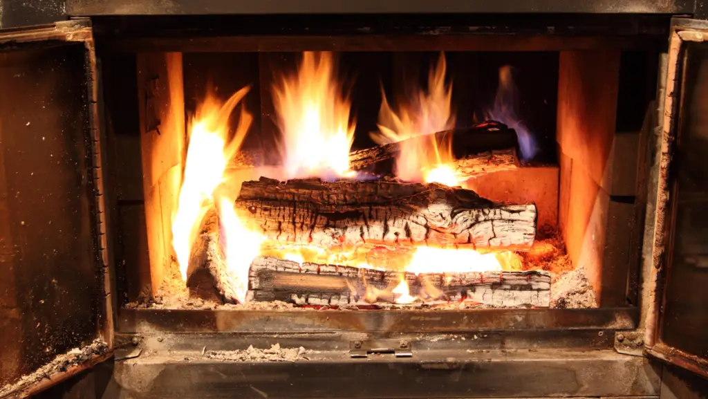 Logs of wood burning inside a opened wood stove