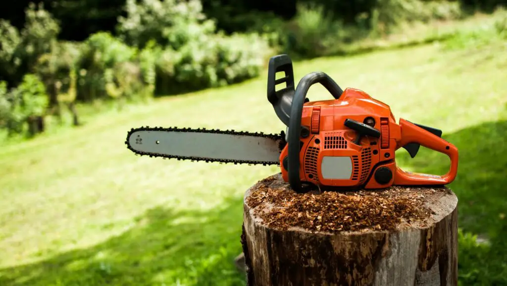 Orange chainsaw on a tree stump